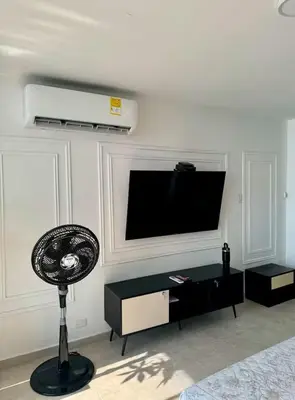 a living room with a flat screen tv and a fan at leslies apartamentos in Cartagena de Indias