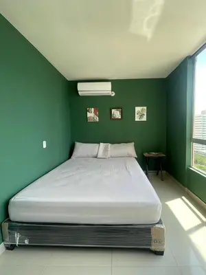 a bed in a bedroom with a green wall at Sea view apartment in Cartagena de Indias