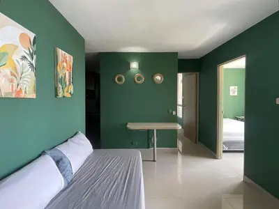 a bedroom with green walls and a bed and a table at Sea view apartment in Cartagena de Indias