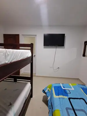 a bedroom with a bunk bed and a flat screen tv on the wall at Casa Hotel Luisa in Cartagena de Indias