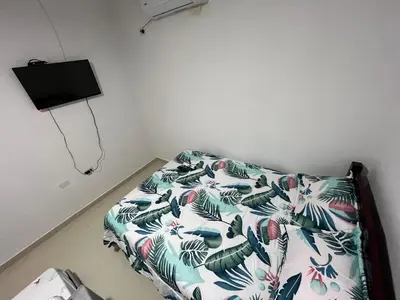 a bed in a room with a comforter on it at Casa Hotel Luisa in Cartagena de Indias