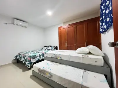 a bedroom with two twin beds and a cabinet at Casa Hotel Luisa in Cartagena de Indias
