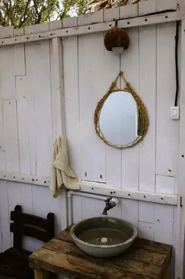 a bathroom with a sink and a mirror on a table at Coco y arena cabaña frente al mar, lejos del turismo y cerca a los manglares in San Bernardo del Viento