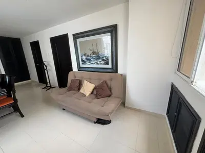 a living room with a couch and a painting on the wall at Laguito Beach Cartagena in Cartagena de Indias