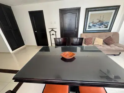 a living room with a table and a couch at Laguito Beach Cartagena in Cartagena de Indias