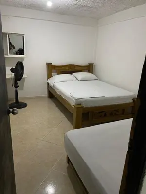a bedroom with two beds and a fan at Apartamento Goyo en Coveñas in Coveñas