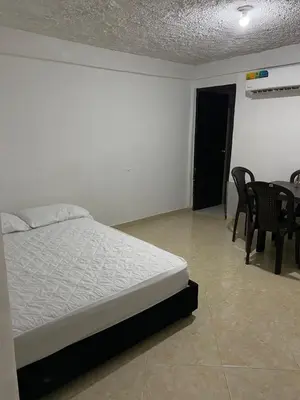 a bedroom with a bed and a table and chairs at Apartamento Goyo en Coveñas in Coveñas