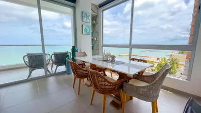 a dining room with a table and chairs and large windows at Magico Apartamento Frente al Mar 4 Habitaciones CB72 in Estación El Salto