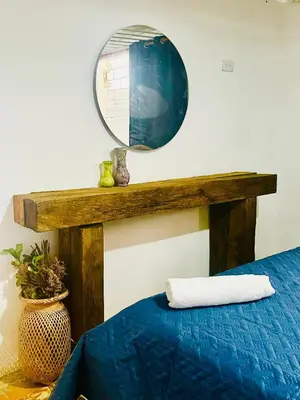 a mirror above a bed with a blue comforter at Lilis house in Cartagena de Indias