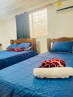a bedroom with two beds with blue sheets and red blankets at Lilis house in Cartagena de Indias