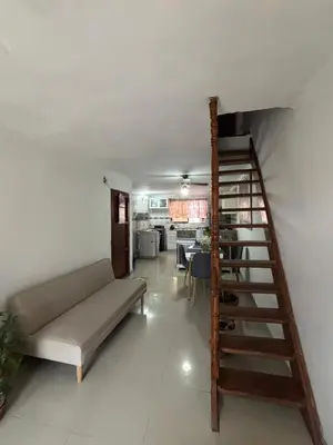 a living room with a couch and a spiral staircase at Ritze's House Getsemani in Cartagena de Indias