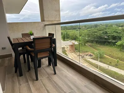 a dining room with a table and chairs and a large window at Baia Kristal Kabo Apartamento in Cartagena de Indias