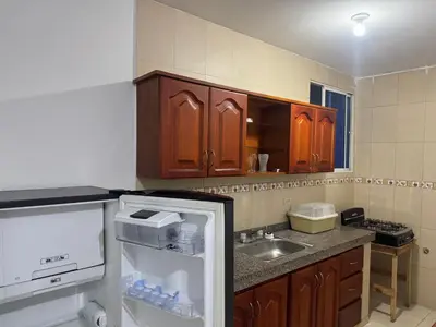 a small kitchen with a refrigerator and a sink at Un lugar cómodo y acogedor in Barranquilla