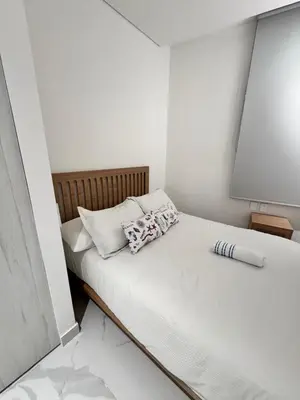 a small white bedroom with a bed with white sheets at Santa marta bello horizonte Swift Lotf in Playa Bello Horizonte