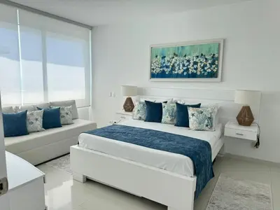 a white bedroom with a large bed and a couch at Luxurious apartment in Morros 3 in Cartagena de Indias