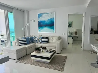 a white living room with a couch and a table at Luxurious apartment in Morros 3 in Cartagena de Indias