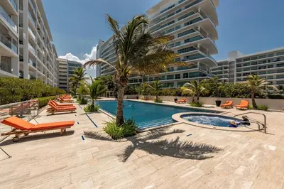 a swimming pool with a palm tree and some buildings at Luxurious apartment in Morros 3 in Cartagena de Indias