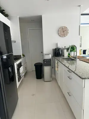 a kitchen with white cabinets and a clock on the wall at Luxurious apartment in Morros 3 in Cartagena de Indias