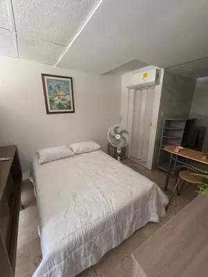a bedroom with a bed and a desk with a fan at apartaestudio ideal manga in Cartagena de Indias