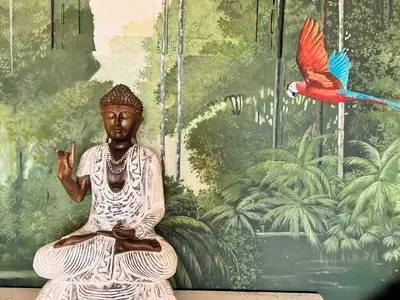 a statue sitting in a room with a bird at Casa Manalva ocean view penthouse in walled city in Cartagena de Indias