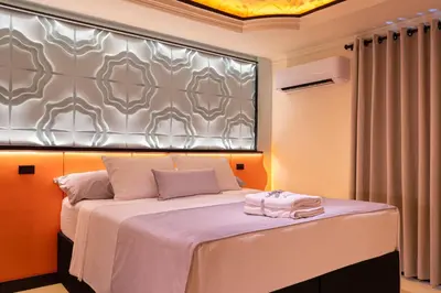 a bedroom with a bed with a silver headboard at Casa Stella Rooms in Cartagena de Indias
