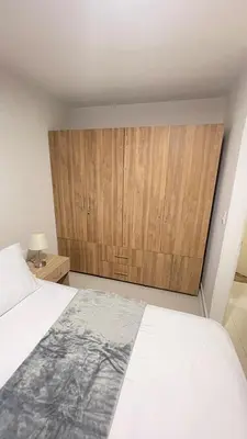 a bedroom with a large bed and a wooden cabinet at Cabrero Beach 507 in Cartagena de Indias