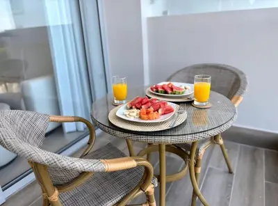 a table with two chairs and two glasses of orange juice at Hermoso apartamento familiar in Cartagena de Indias