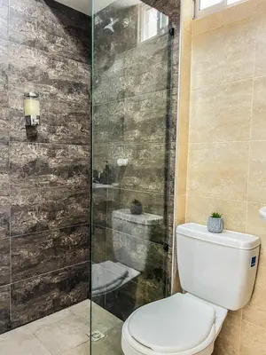 a bathroom with a toilet and a glass shower at Apartamento Ideal cerca de Zona Industrial, Terminal y Centro Comercial in Cartagena de Indias