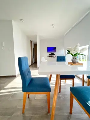 a dining room with a white table and blue chairs at Apartamento Ideal cerca de Zona Industrial, Terminal y Centro Comercial in Cartagena de Indias