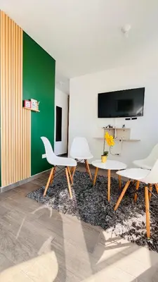 a living room with white furniture and a green wall at Apartamento Ideal cerca de Zona Industrial, Terminal y Centro Comercial in Cartagena de Indias