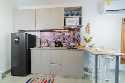 a kitchen with a black refrigerator and a counter at Apartamento con playa y piscina a 5 minutos del aeropuerto in Santa Marta