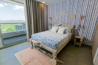 a bedroom with a bed with a blue and white comforter at Apartamento con playa y piscina a 5 minutos del aeropuerto in Santa Marta