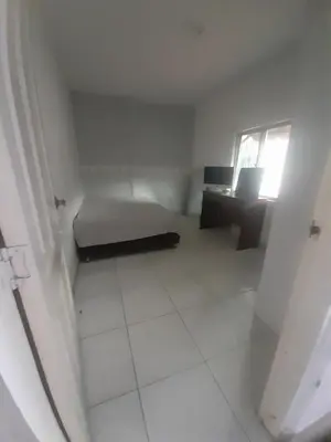 a small white room with a bed and a desk at Rey SALOMÓN SALJA in Barranquilla