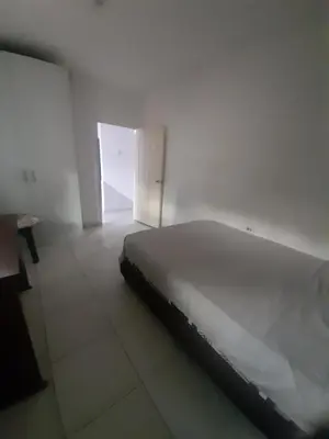 a bed in a white room with an open door at Rey SALOMÓN SALJA in Barranquilla