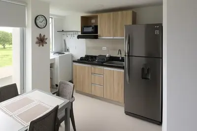 a kitchen with a refrigerator and a table with chairs at Mirador de la Reserva Coveñas in Coveñas