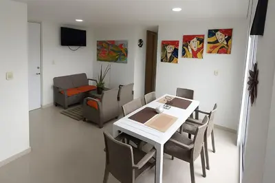 a dining room with a white table and chairs at Mirador de la Reserva Coveñas in Coveñas
