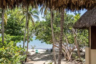 a beach with a bunch of trees and the ocean at Villa Frente al mar en el Calao, San Antero in Calao