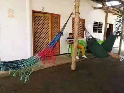 two boys sitting in hammocks outside a house at Playas el paraiso in San Bernardo del Viento