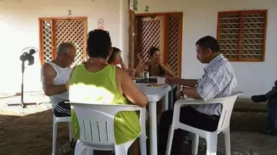a group of people sitting at a table at Playas el paraiso in San Bernardo del Viento