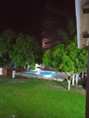 a swimming pool in a yard at night at Cabaña villa in Sabanagrande