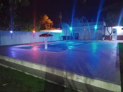 an umbrella in the middle of a pool at night at Cabaña villa in Sabanagrande