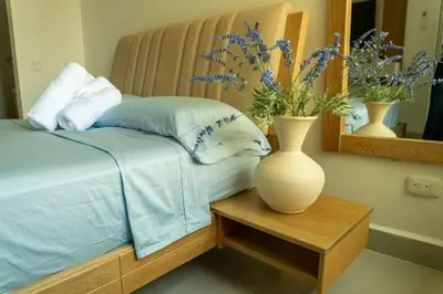 a bedroom with a bed with a vase on a table at Beach house in Cartagena de Indias