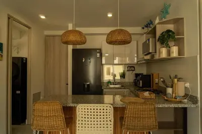 a kitchen with a counter with chairs and a refrigerator at Beach house in Cartagena de Indias