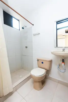 a bathroom with a toilet and a sink at Hotel Costa Caribe BAQ in Barranquilla