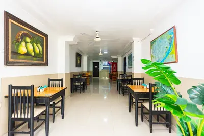 a restaurant with tables and chairs and a painting on the wall at Hotel Costa Caribe BAQ in Barranquilla