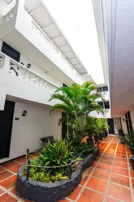 a lobby with palm trees in a building at Hotel Costa Caribe BAQ in Barranquilla