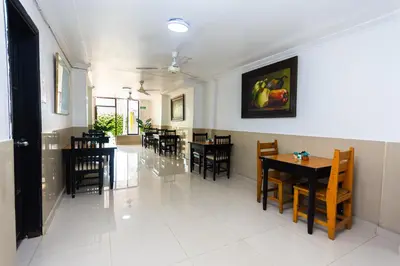 a dining room with tables and chairs and a painting on the wall at Hotel Costa Caribe BAQ in Barranquilla