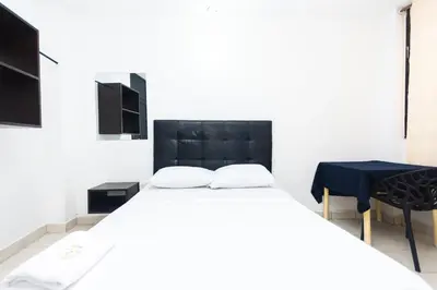 a bedroom with a large bed and a table at Hotel Costa Caribe BAQ in Barranquilla