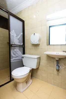 a bathroom with a toilet and a sink at Hotel Costa Caribe BAQ in Barranquilla