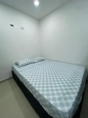 a bed with a blue and white checkered mattress at Apartamento 9 pax En Cartagena in Cartagena de Indias